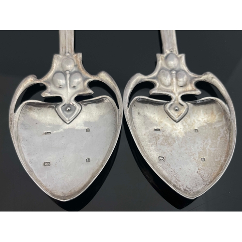 71 - A pair of Arts and Crafts silver spoons, TW, Birmingham 1901, the planished spade bowls on open tend... 