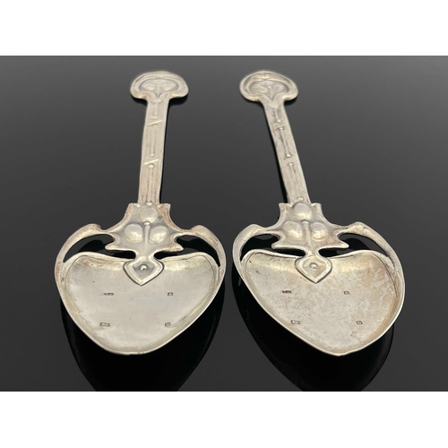 71 - A pair of Arts and Crafts silver spoons, TW, Birmingham 1901, the planished spade bowls on open tend... 