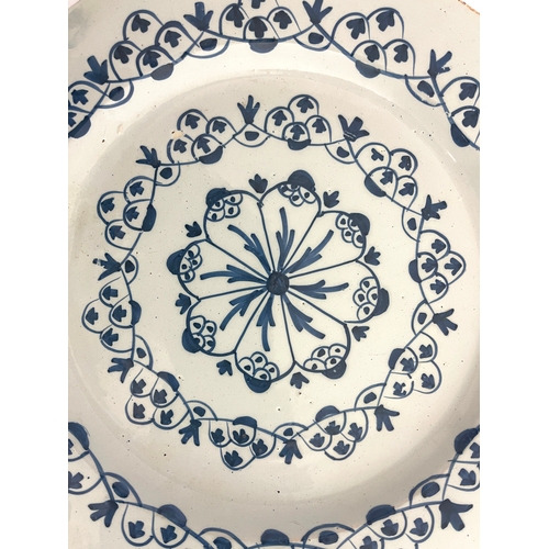 636 - A Delft blue and white broad rimmed charger, circa 1720, painted with geometric foliate swags and a ... 