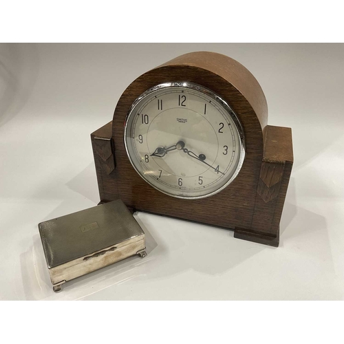 141C - A Smiths Enfield oak cased mantel clock, together with a silver plated wooden lined cigarette box, e... 