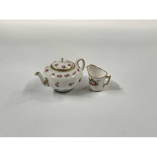 146C - A Royal Crown Derby rose painted miniature teapot, 5cm high and a miniature cream jug decorated with... 