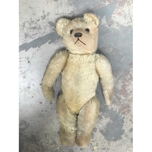 157 - A straw-filled golden plush teddy bear, glass eyes, horizontally stitched nose, jointed limbs, cloth... 