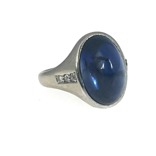 4 - A synthetic sapphire cabochon band ring, white metal (probably platinum) with diamond line shoulders... 