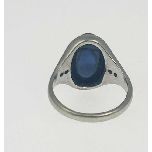 4 - A synthetic sapphire cabochon band ring, white metal (probably platinum) with diamond line shoulders... 