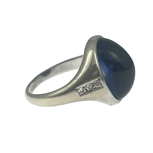 4 - A synthetic sapphire cabochon band ring, white metal (probably platinum) with diamond line shoulders... 