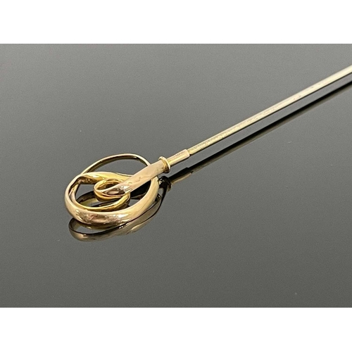 46 - An Arts and Crafts 15 carat gold finial hat pin, probably Charles Horner, circa 1905, knotted ribbon... 