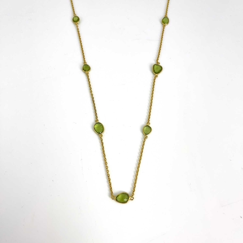 62 - Kristina Charrington, a silver gilt peridot necklace, collet set twenty graduated oval peridot