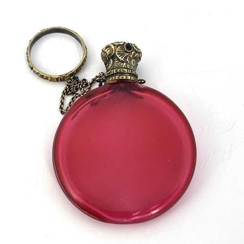 77 - A Victorian silver gilt and cranberry glass scent bottle, circa 1840, the flattened disc form body w... 