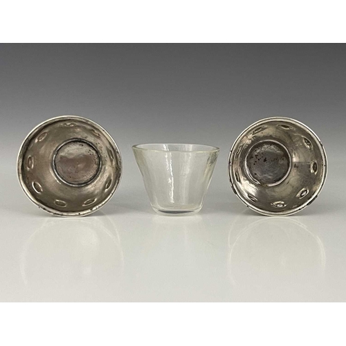 94 - Bernard Cuzner, a pair of Arts and Crafts silver salt cellars, Birmingham 1905, conical footed bucke... 