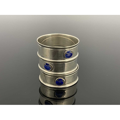 104 - Charles Horner, three Arts and Crafts silver and enamelled napkin rings, Chester 1917 and 1923, circ... 