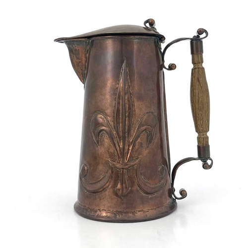 155 - An Arts and Crafts copper lidded jug, repousse embossed with fleur de lys motifs to each side, rivet... 