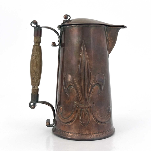 155 - An Arts and Crafts copper lidded jug, repousse embossed with fleur de lys motifs to each side, rivet... 