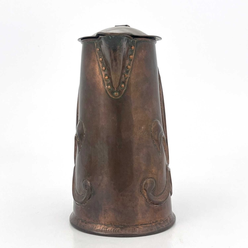 155 - An Arts and Crafts copper lidded jug, repousse embossed with fleur de lys motifs to each side, rivet... 