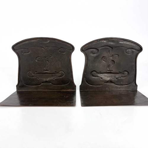 157 - A pair of Arts and Crafts copper bookends, repousse embossed and planished with stylised Roman oil l... 