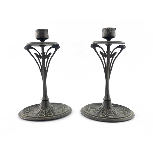 170 - A pair of bronze Art Nouveau candlesticks, disc drip-pan on sinuous openwork stem to circular dished... 