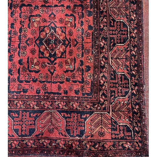 207 - An Afghan tribal rug, possibly Khal Mohammadi, four rows of two geometric medallions in centre withi... 