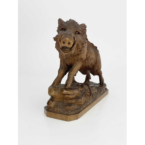 221 - A Black Forest carved wood figure of a boar, 19th century, realistically modelled on a rocky outcrop... 