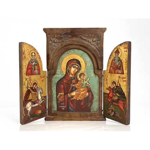 224 - A Greek Orthodox triptych ikon, wooden frame with leaf-carved spandrels to the pediment, hinged doub... 