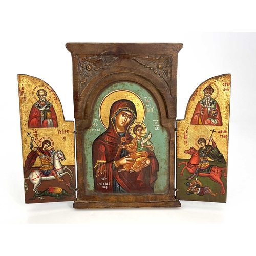 224 - A Greek Orthodox triptych ikon, wooden frame with leaf-carved spandrels to the pediment, hinged doub... 