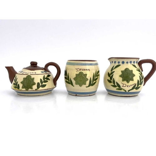 250 - A Devon Regiment Torquay Ware three piece tea set, applied with the regimental badge to each