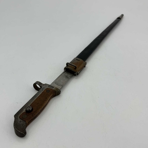 275 - A Danish M1889 KragJørgensen carbine bayonet, two piece wooden grip housed in black leather mounted... 