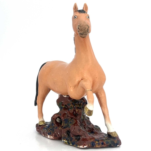 448 - A Chinese porcelain figure, 19th century, modelled as a figure of a colt, with black mane and tail, ... 