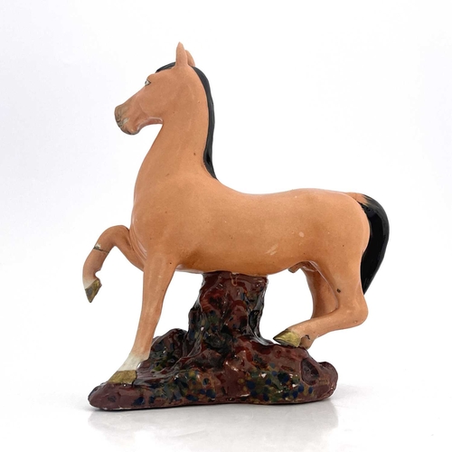 448 - A Chinese porcelain figure, 19th century, modelled as a figure of a colt, with black mane and tail, ... 