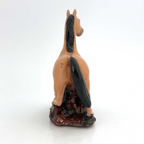 448 - A Chinese porcelain figure, 19th century, modelled as a figure of a colt, with black mane and tail, ... 