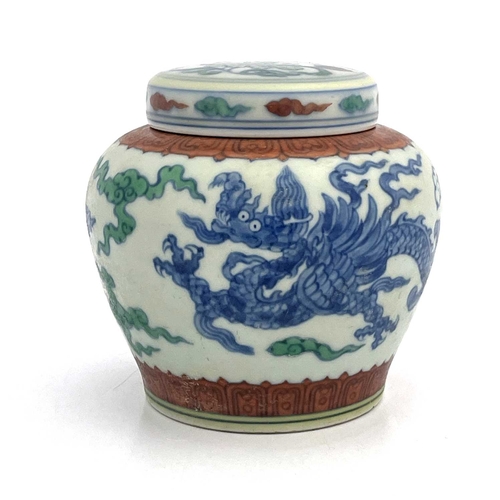 455 - A Chinese Doucai porcelain jar and cover, squat baluster form, painted with blue dragons within terr... 