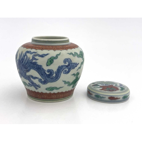 455 - A Chinese Doucai porcelain jar and cover, squat baluster form, painted with blue dragons within terr... 