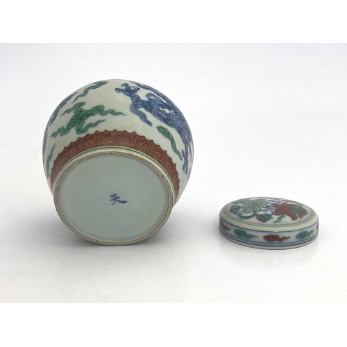 455 - A Chinese Doucai porcelain jar and cover, squat baluster form, painted with blue dragons within terr... 