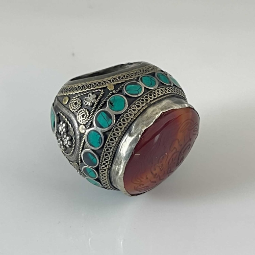 457 - A large Islamic ring of bulbous form, 19th Century, the wrought metalwork inlaid with turquoise ston... 