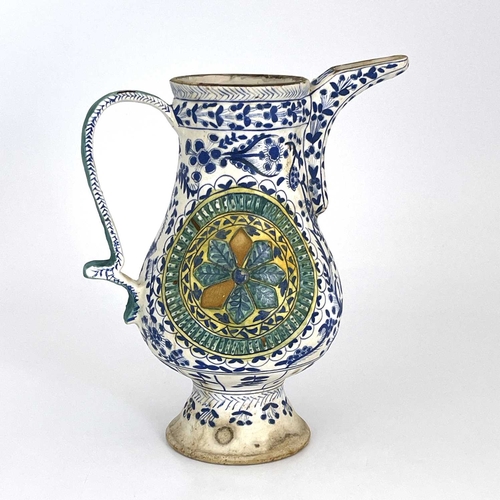 460 - A Turkish Ottoman pottery ewer, footed baluster form, relief moulded floral roundels within blue and... 