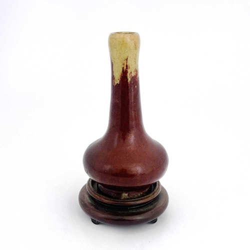 475 - A Chinese sang de boeuf glazed pottery vase, bulbous form, hares fur ochre over red glaze, on a wood... 