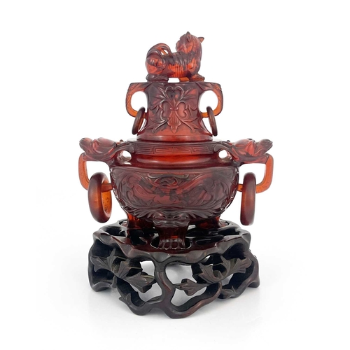 485 - A Chinese pressed cherry amber censer, ring handles and lid, modelled in low relief with foliate scr... 