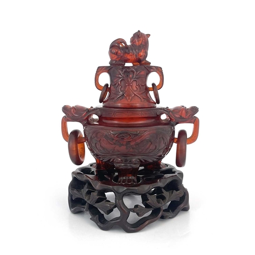 485 - A Chinese pressed cherry amber censer, ring handles and lid, modelled in low relief with foliate scr... 