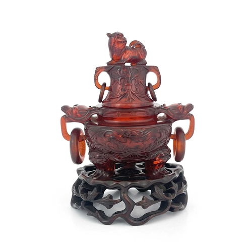 485 - A Chinese pressed cherry amber censer, ring handles and lid, modelled in low relief with foliate scr... 