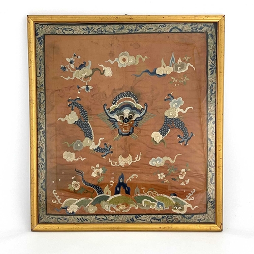 490 - A Chinese silk embroidered panel, decorated with dragon amongst clouds, on rust coloured ground, 65c... 