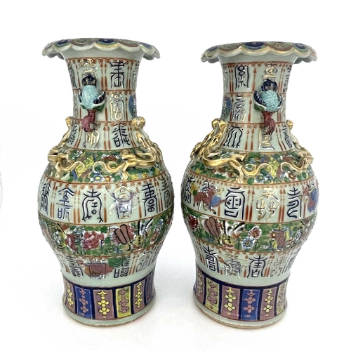 495 - A pair of Chinese vases, twin handled, celadon ground with bands of relief moulded characters, appli... 