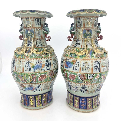 495 - A pair of Chinese vases, twin handled, celadon ground with bands of relief moulded characters, appli... 