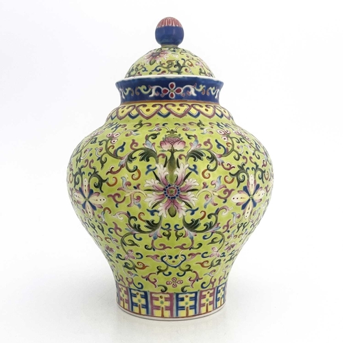 496 - A Chinese porcelain lime green lidded vase, 19th Century, of baluster form, intricately decorated wi... 