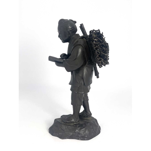 501 - A Japanese bronze figure, Meiji, modelled as a travelling man reading a book, 37cm high