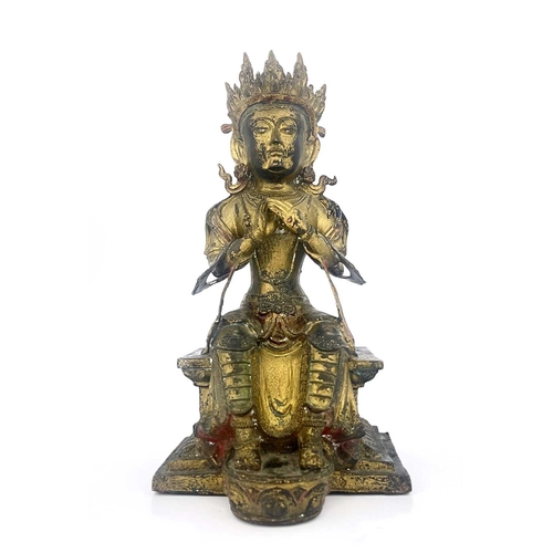 509 - An Oriental gilt bronze figure of Tara, modelled sitting on a plinth, highlighted in polychrome enam... 