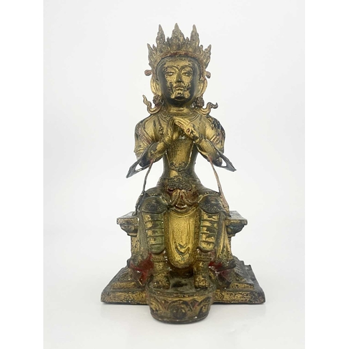 509 - An Oriental gilt bronze figure of Tara, modelled sitting on a plinth, highlighted in polychrome enam... 