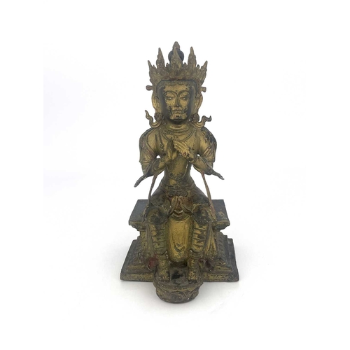 509 - An Oriental gilt bronze figure of Tara, modelled sitting on a plinth, highlighted in polychrome enam... 