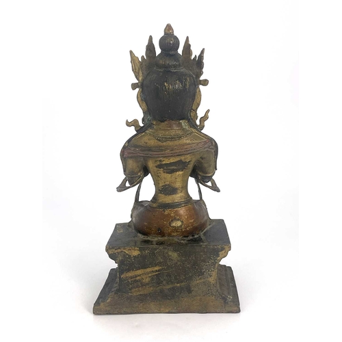 509 - An Oriental gilt bronze figure of Tara, modelled sitting on a plinth, highlighted in polychrome enam... 