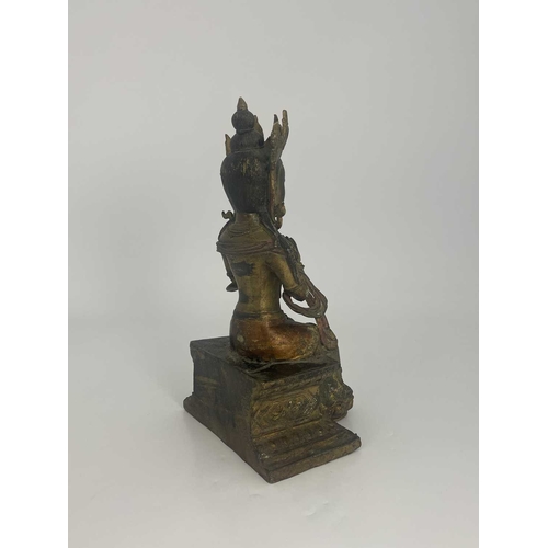 509 - An Oriental gilt bronze figure of Tara, modelled sitting on a plinth, highlighted in polychrome enam... 