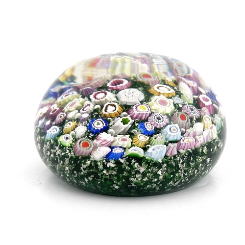 512 - Riedel, a random cane millefiori glass paperweight, late 19th century, mica gravel green ground with... 