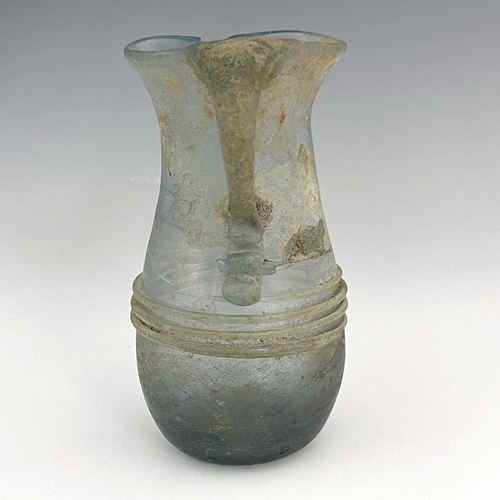 514 - A Roman glass jug, probably late Imperial, baluster form with applied trailing and loop handle, 16cm... 