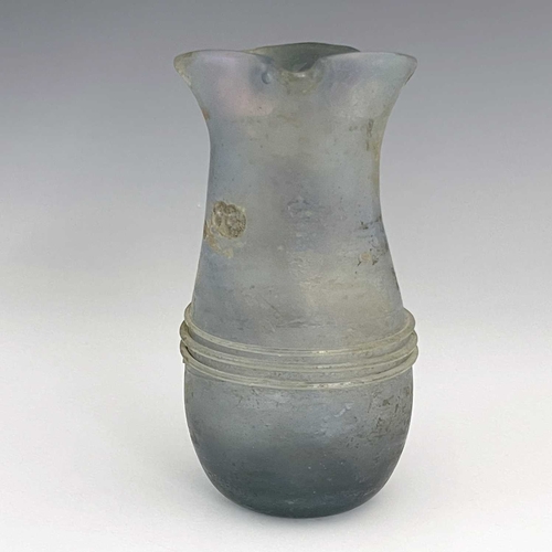 514 - A Roman glass jug, probably late Imperial, baluster form with applied trailing and loop handle, 16cm... 